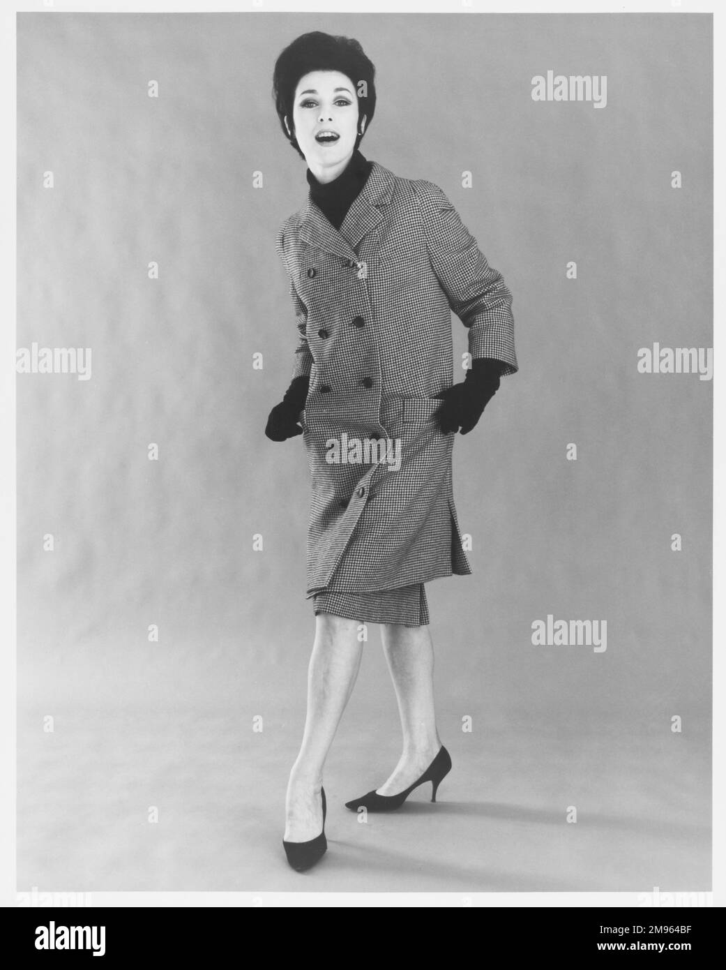 Ritratto integrale di una donna in un camice di ginocchio con gonna coordinata. Foto Stock