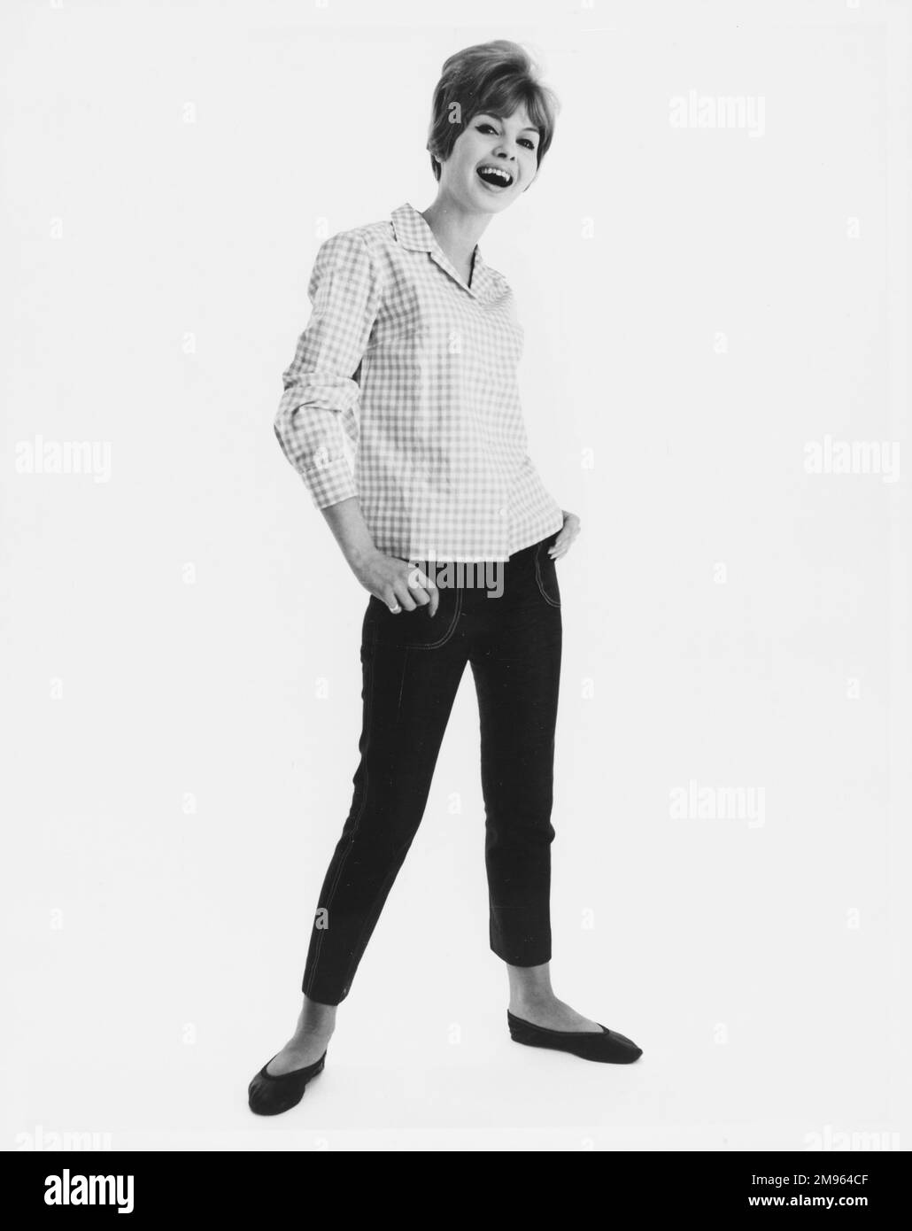 Ritratto a tutta lunghezza di un modello in una camicia a quadri e jeans corti in posa per la fotocamera. Foto Stock