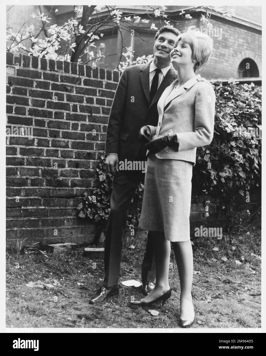 Una coppia ha uno sguardo al retro di una casa che sono interessati ad acquistare. Foto Stock