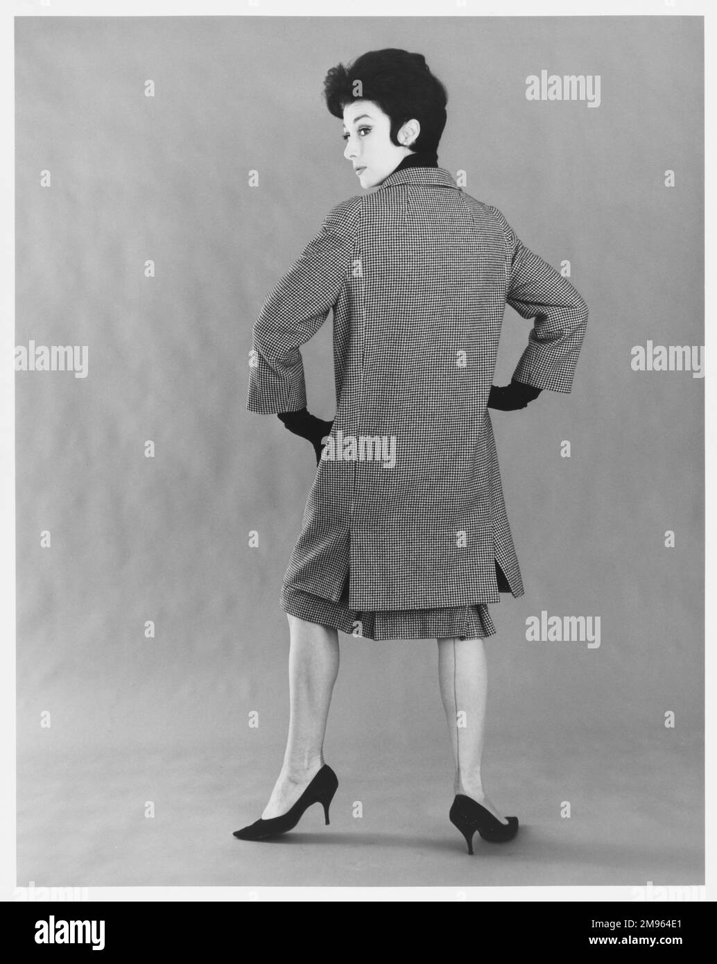 Ritratto integrale di una donna in un camice di ginocchio con gonna coordinata. Foto Stock