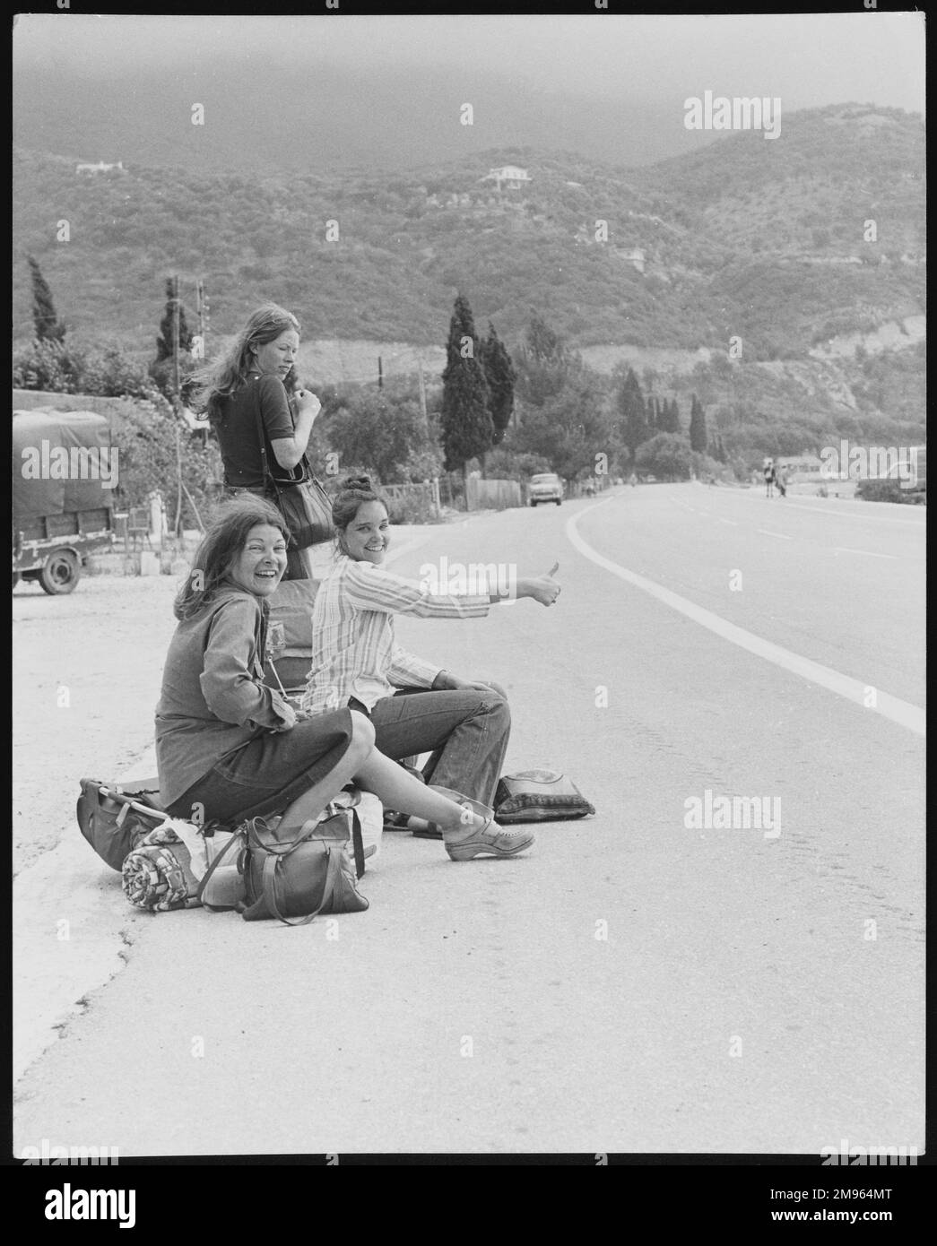 Donne hitch-hikers su una strada a Ipsos, Corfù, Grecia. Foto Stock
