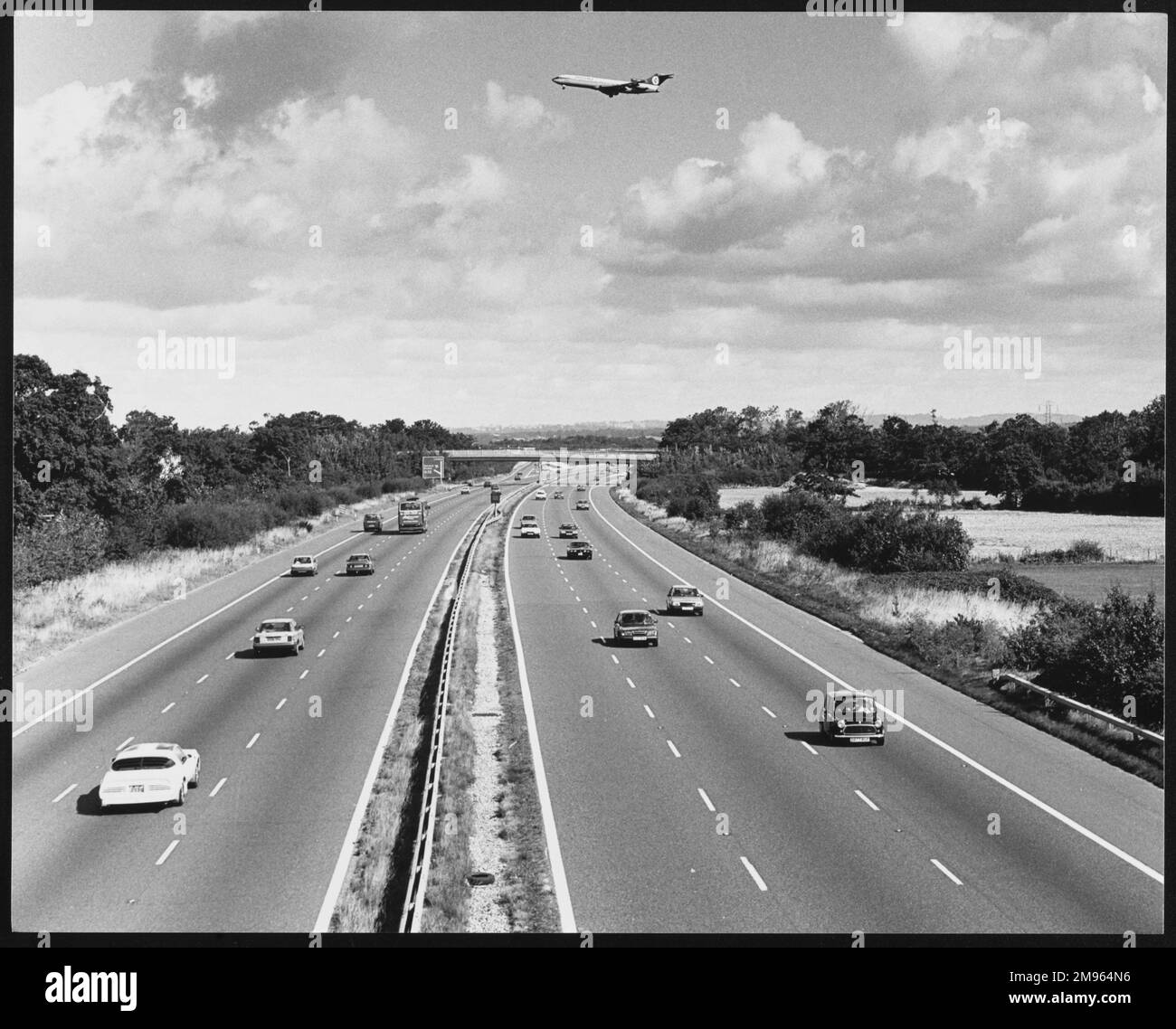 Un aereo che sorvola l'autostrada M23 in direzione dell'aeroporto Gatwick di Londra. Foto Stock