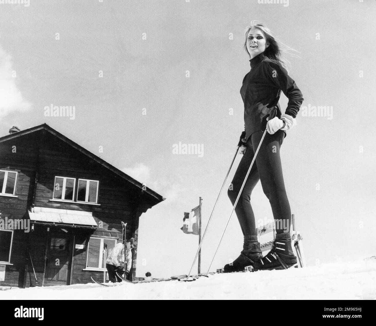 Un modello biondo sugli sci, posto all'esterno di uno chalet. Foto Stock
