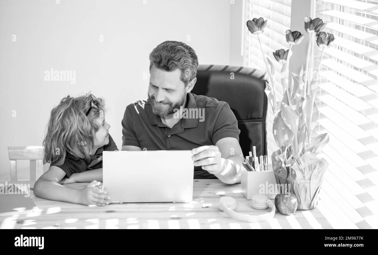 ritorno a scuola. padre e figlio usano la tecnologia di comunicazione a casa. Foto Stock