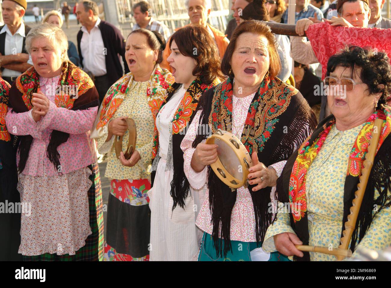 Un gruppo di donne appartenenti ad un gruppo folcloristico di Porto da Cruz, a Funchal, la capitale di Madeira. Cantano e suonano strumenti a percussione come parte del loro intrattenimento di strada. Foto Stock