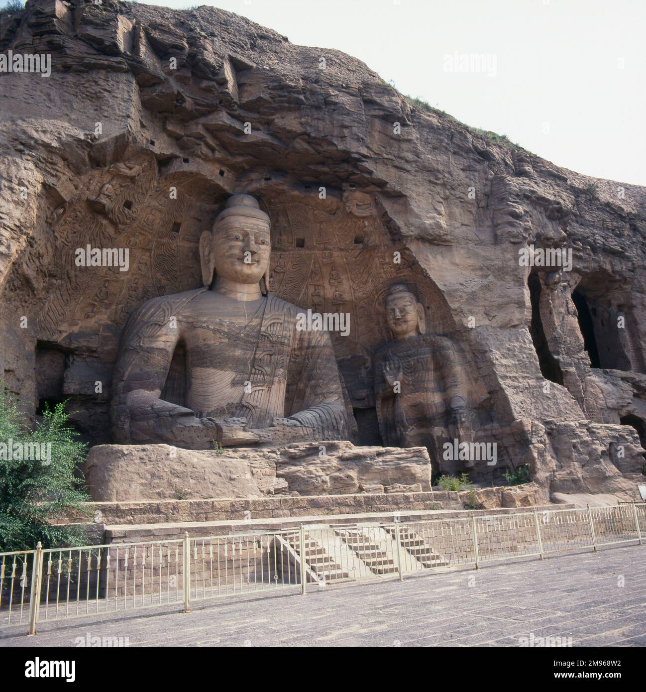 Due statue di Buddha di varie dimensioni scolpite dalla roccia nelle grotte o grotte di Yungang (Cloud Ridge) a Datong, nella provincia di Shanxi, nella Repubblica popolare Cinese. Foto Stock