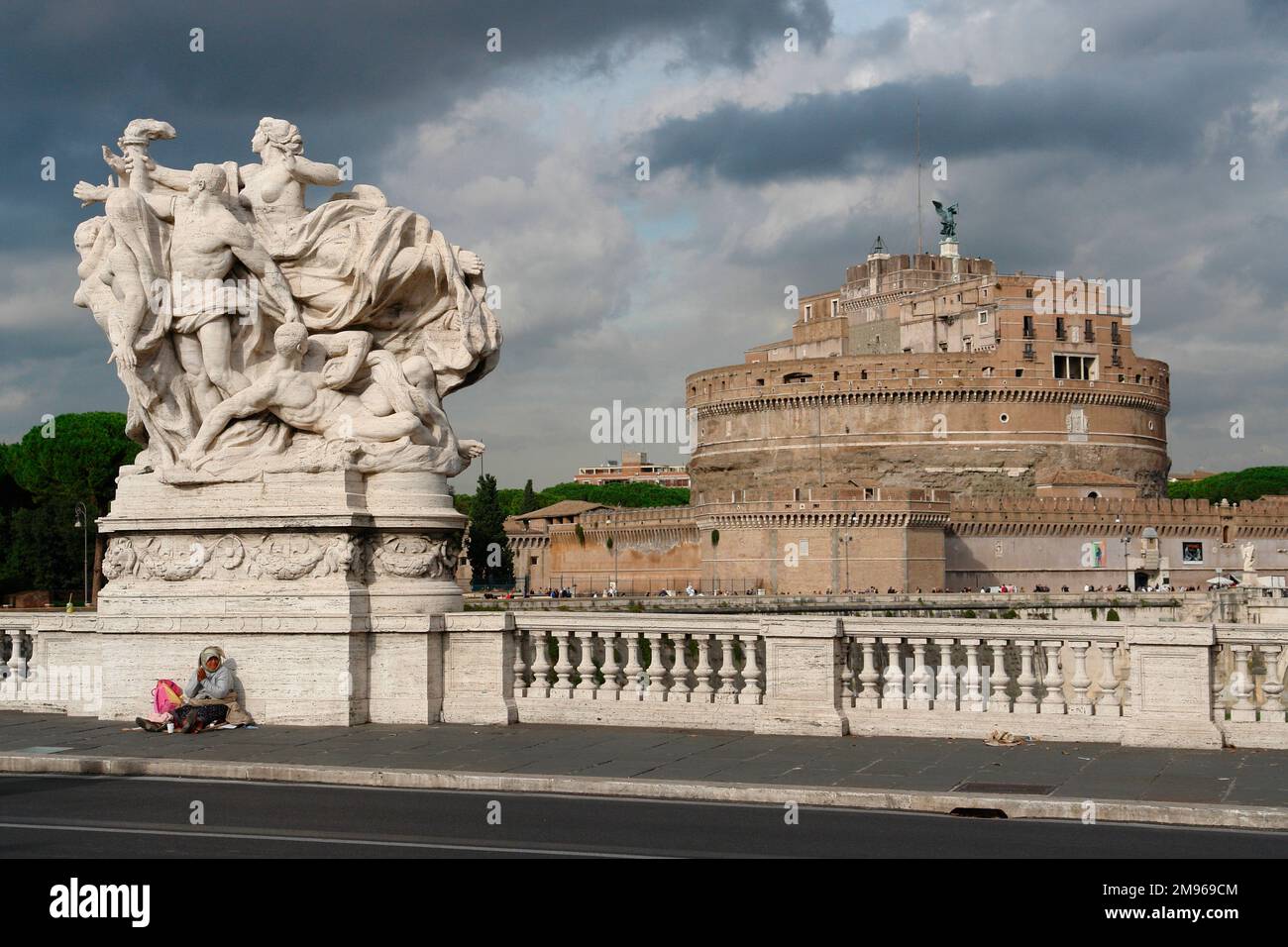 Vista di una grande scultura sul Ponte Vittorio Emanuele II sul Tevere, con il Castel Sant'Angelo (talvolta noto anche come Mausoleo di Adriano) in lontananza a destra, a Roma. Foto Stock