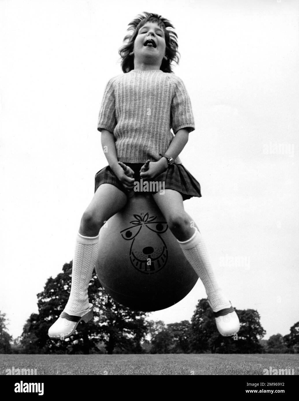 Una ragazza giovane rimbalza lungo sulla sua spacehopper, abbastanza chiaramente avendo lotti di divertimento. (Immagine 4 su 4) Foto Stock