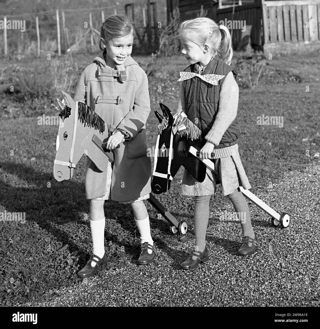 Due ragazze (gemelli non identici) che cavalcano i loro cavalli hobby. Foto Stock