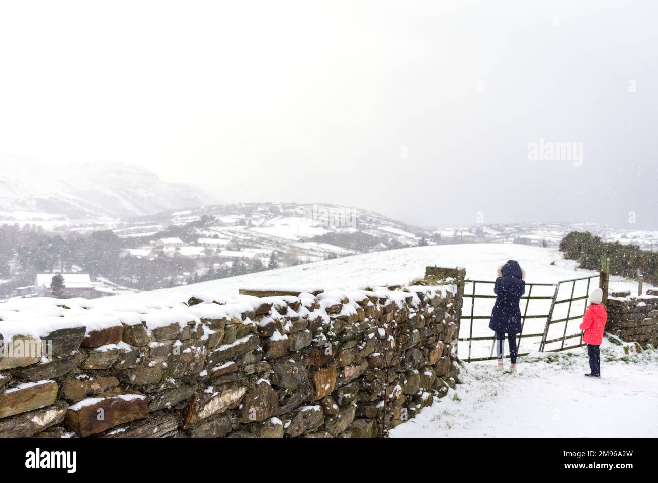 Ardara, Contea di Donegal, Ireland Weather. 17th gennaio 2023. Una donna e un bambino guardano fuori come la neve continua a cadere nella contea nord-occidentale. Foto Stock