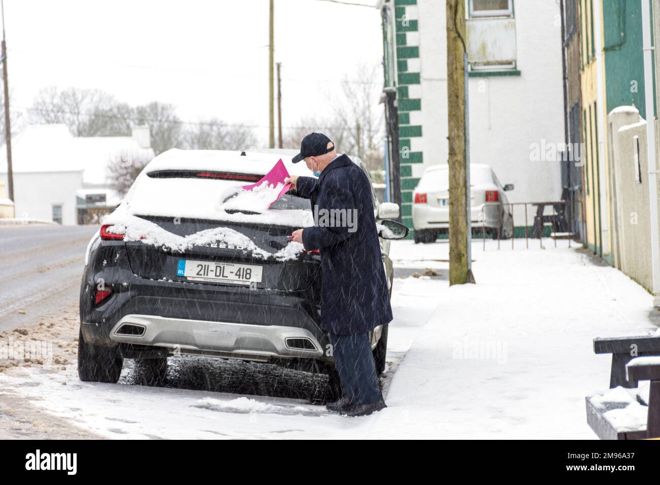 Ardara, Contea di Donegal, Ireland Weather. 17th gennaio 2023. Un uomo libera la neve dal parabrezza della sua auto mentre la neve continua a cadere nella contea nord-occidentale. Foto Stock