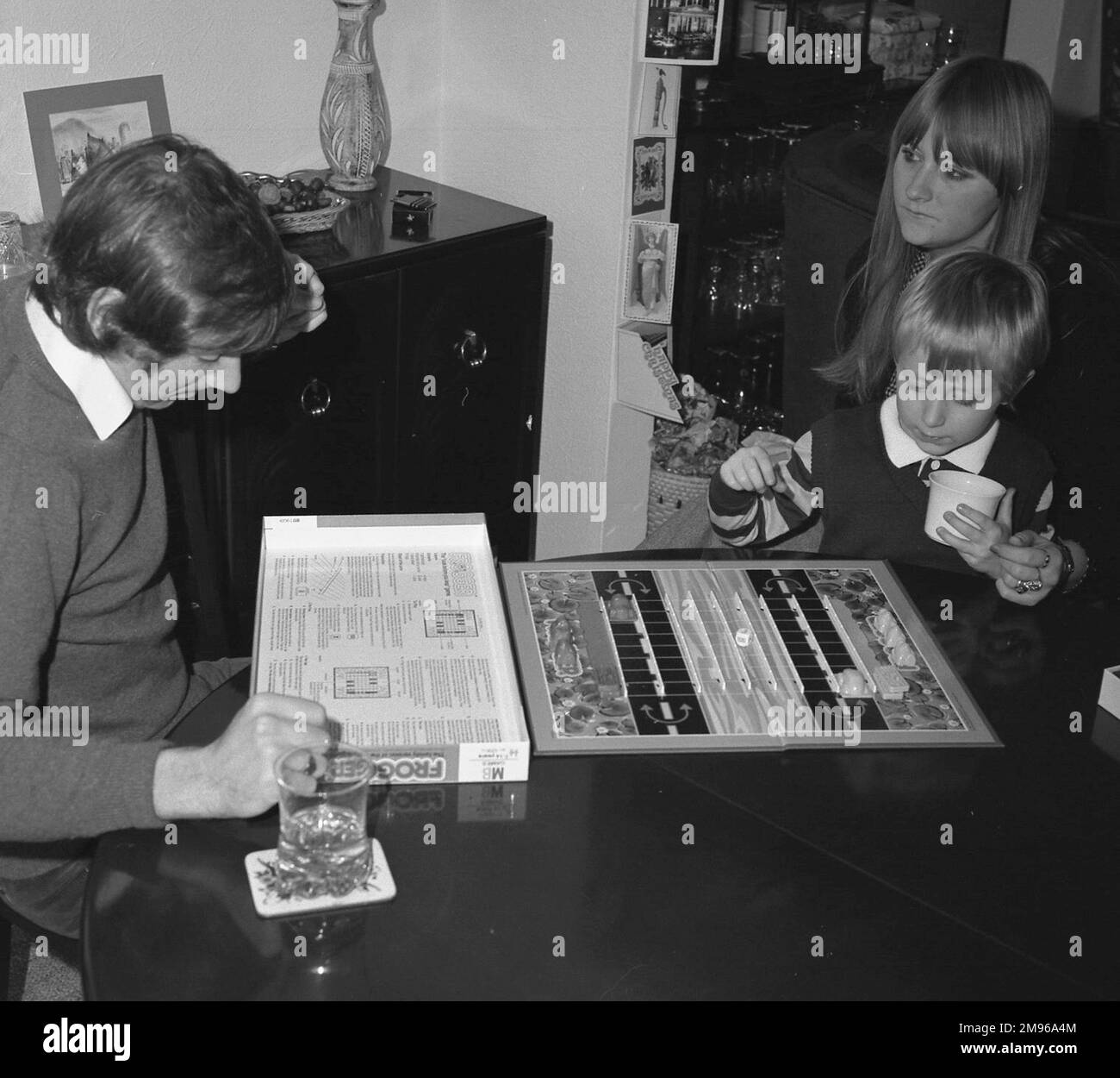 Un uomo che legge le regole del gioco da tavolo Frogger, che si basava sul popolare arcade e videogioco dello stesso nome ed è stato portato fuori da Milton Bradley nel 1981. La versione del gioco da tavolo è per due giocatori, ai quali viene assegnata la propria fornitura di rane, tronchi e auto. Lo scopo del gioco è quello di spostare le rane all'altro lato del tabellone, spostare tronchi e auto per bloccare l'altro giocatore. I punti bonus vengono assegnati per l'atterraggio sulle mosche! Foto Stock
