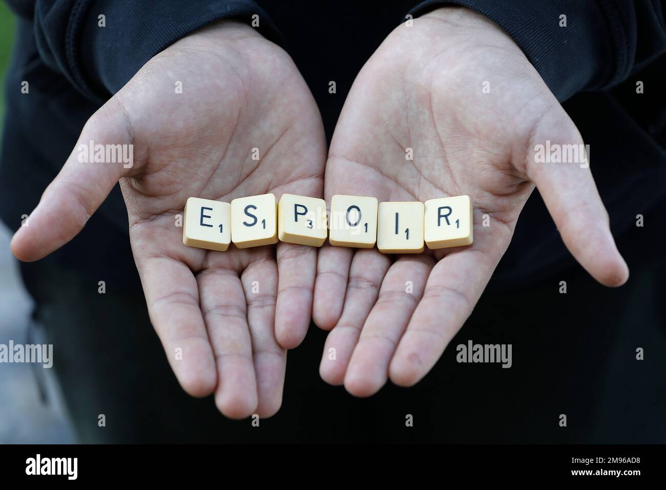 Ragazzo che mostra lettere spelling espoir (speranza) in Eure, Francia Foto Stock