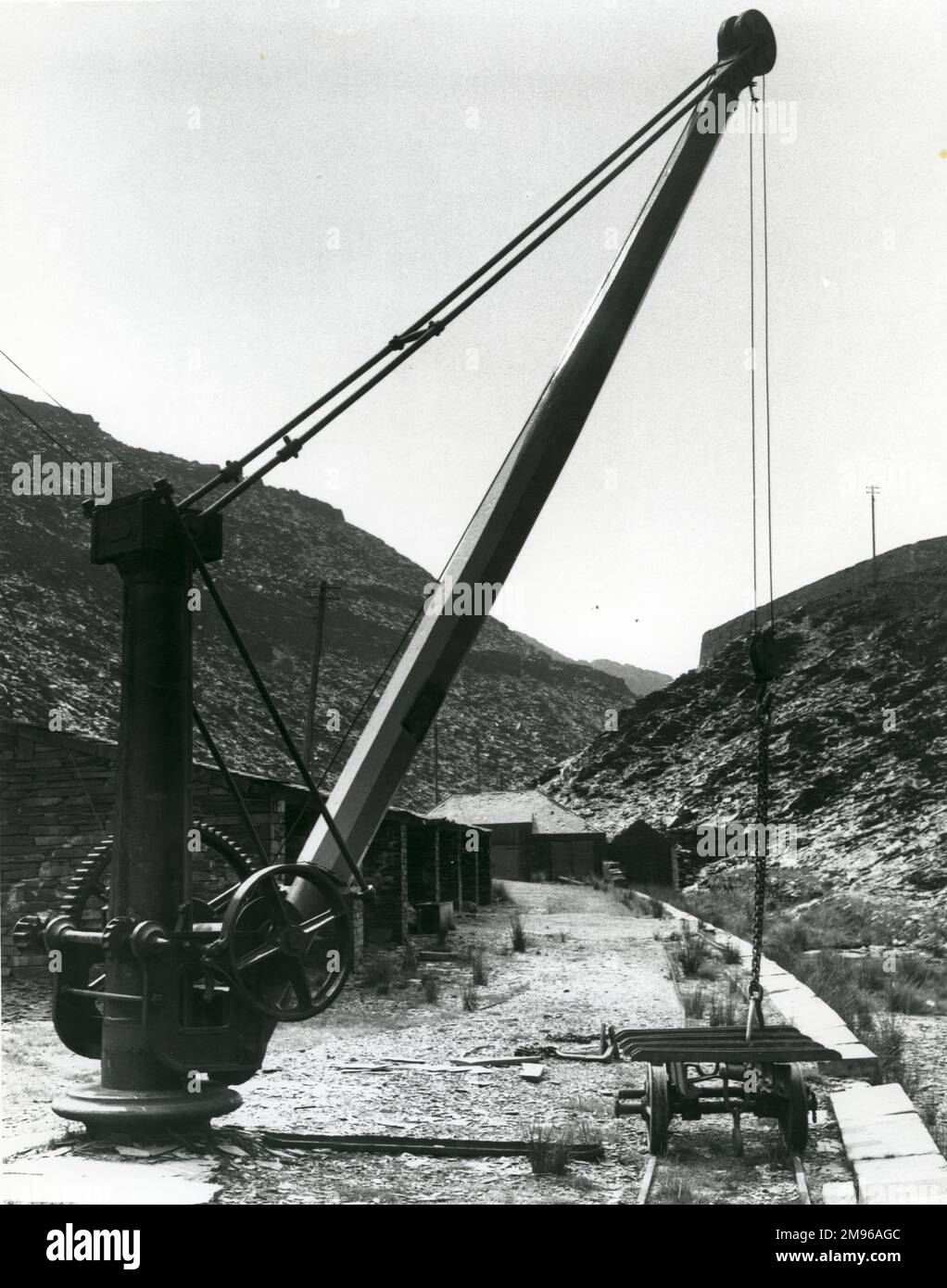 Vista della cava di ardesia Rhiwbryfdir, vicino a Blaenau Ffestiniog, Caernarvonshire (ora Gwynedd), Galles del Nord, con il negozio di ardesia, una gru e il tram a scartamento ridotto che trasportava l'ardesia durante la lavorazione. Foto Stock