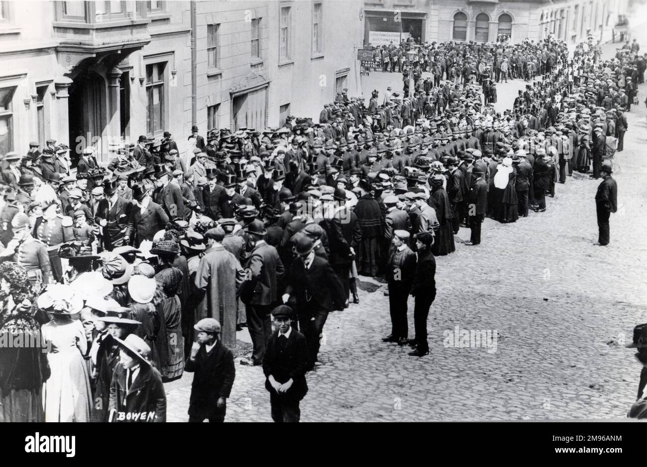 Un'occasione speciale nella zona di High Street e Castle Square di Haverfordwest, Pembrokeshire, Dyfed, Galles del Sud, forse per la presentazione di un memoriale ai soldati della guerra dei boeri. Un gruppo di dignitari in cappelli di alto livello, insieme a file di poliziotti, si processa per strada, mentre le folle di cittadini ben educati si alzano a guardare. Foto Stock