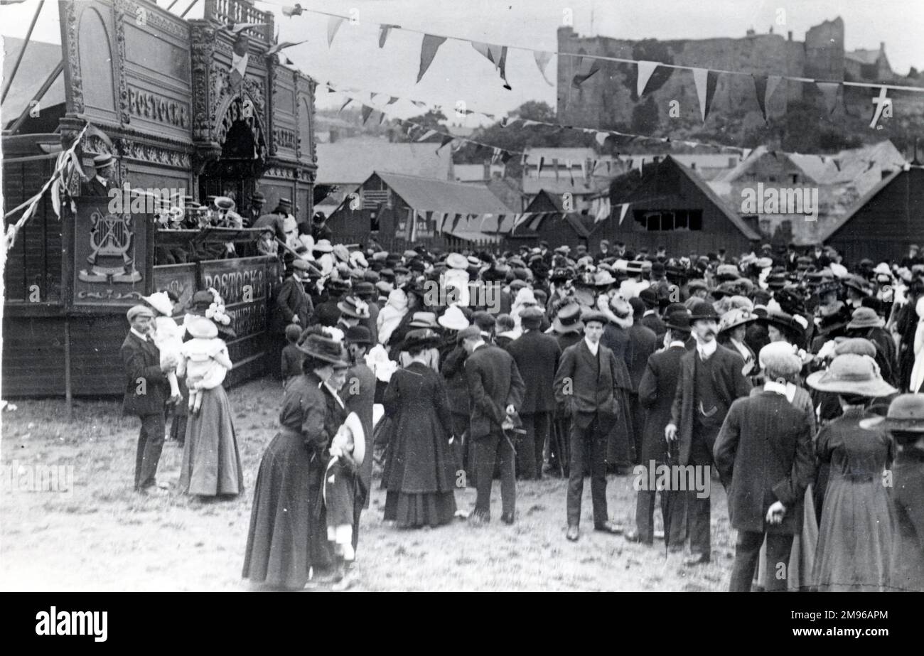 Folle di persone che si macchiano intorno alla fiera, sulla terra adiacente al New Bridge a Haverfordwest, Pembrokeshire, Dyfed, Galles del Sud. Il cinema Bostock e Wombwell è visibile sulla sinistra, una delle principali attrazioni con le più recenti tecnologie per le immagini in movimento. Foto Stock