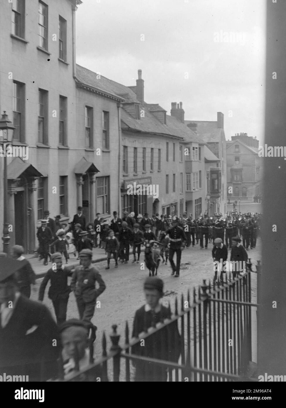 Una sfilata, compresa una banda di ottoni, si fa strada sulla High Street a Haverfordwest, Pembrokeshire, Dyfed, Galles del Sud. Foto Stock
