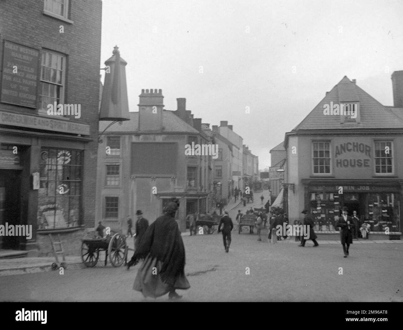 Una scena di strada a Carmarthen, la città della contea di Carmarthenshire, Dyfed, Galles del Sud. Il negozio di alimentari sulla sinistra mostra una grande caffettiera all'angolo dell'edificio. Foto Stock