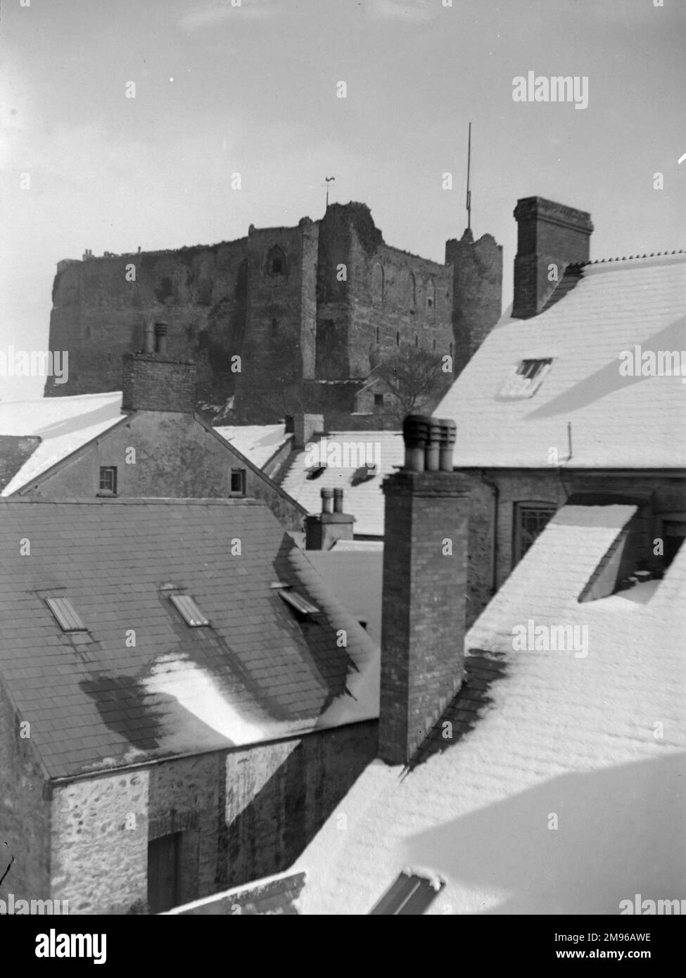 Vista del Castello attraverso i tetti, da un edificio in High Street, Haverfordwest, Pembrokeshire, Dyfed, Galles del Sud. C'è stata una recente caduta di neve. Il castello risale al 12th ° secolo. Foto Stock