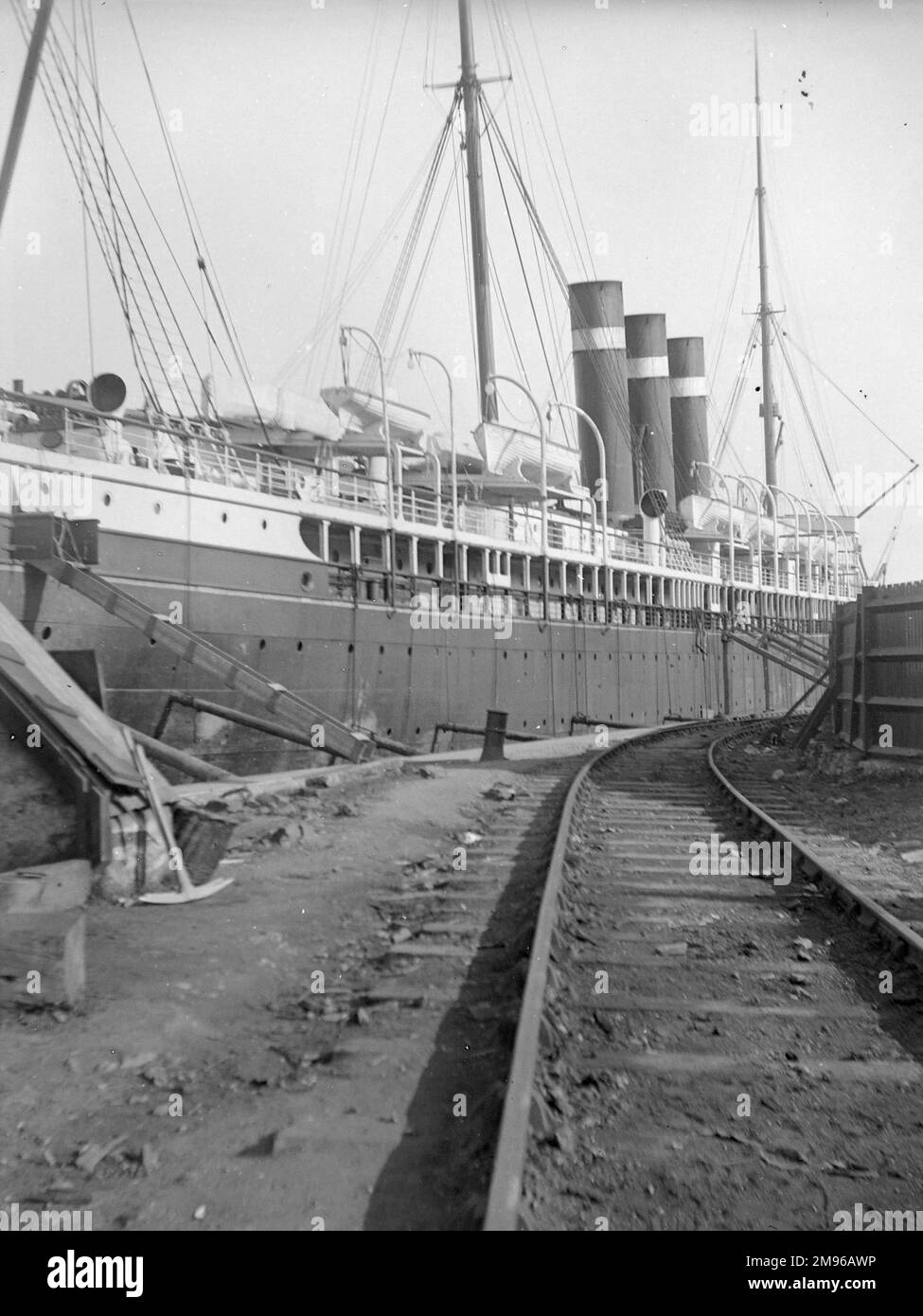 Vista della città di Parigi nave in riparazione a Milford Haven Docks, Galles del Sud, con una linea ferroviaria in primo piano. Foto Stock