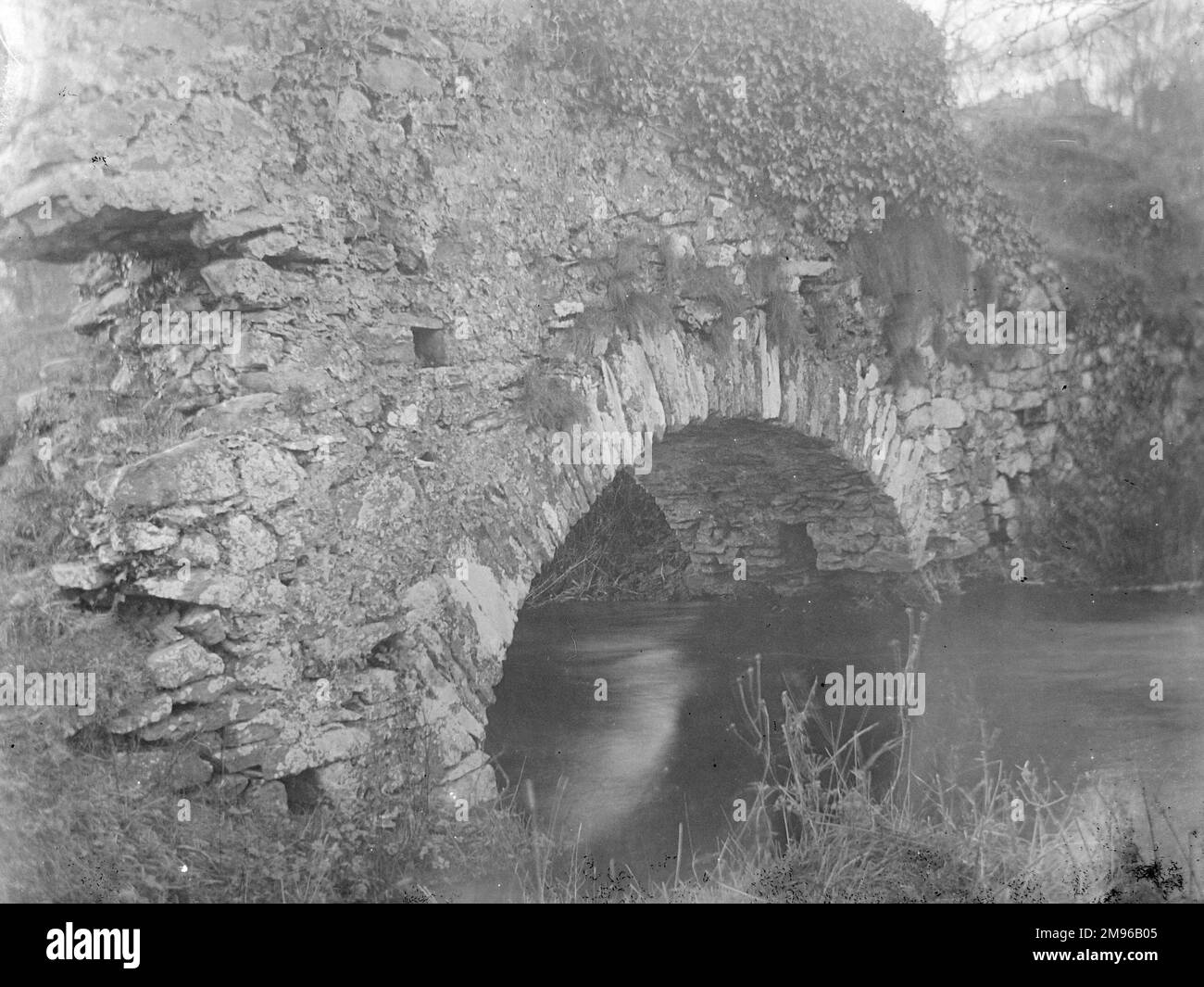 Vista di un vecchio ponte di pietra sul fiume Alyn, che conduce alla Cattedrale di San David e al Palazzo Vescovile, a San David, a Pembrokeshire, a Dyfed, nel Galles del Sud. Foto Stock