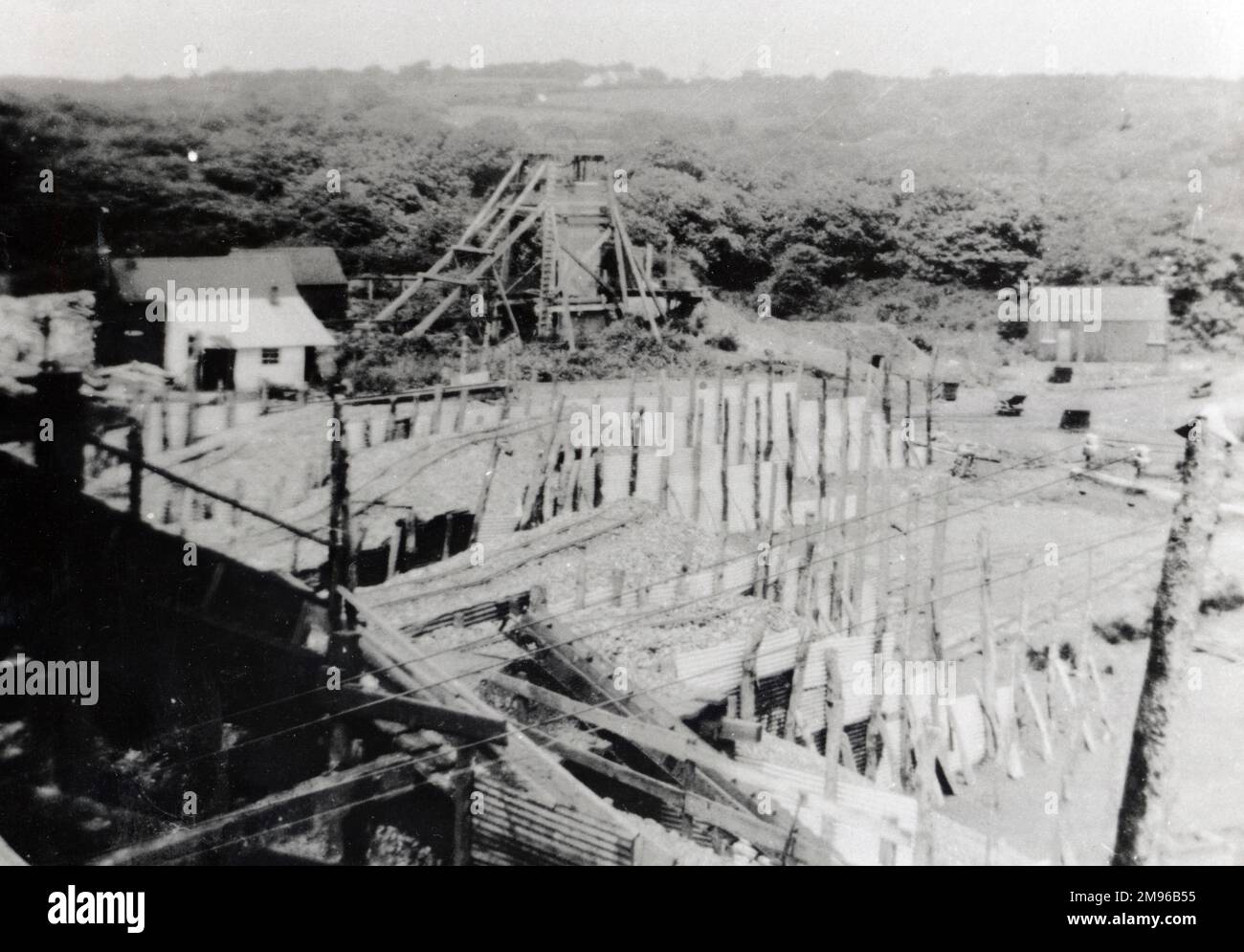 Una vista di Hook Colliery, vicino a Haverfordwest, Pembrokeshire, Galles del Sud, che mostra la ruota dentata in legno a metà distanza, e alcuni edifici. Foto Stock