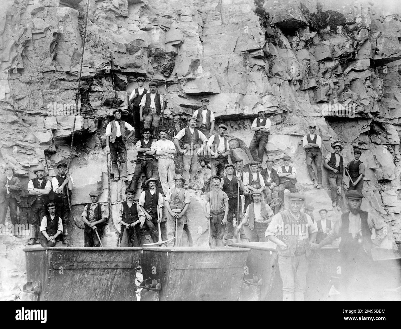 Un grande gruppo di navi della Great Western Railway che lavorano sulla ferrovia Treffgarne a Nant Y Coy, Pembrokeshire, Dyfed, Galles del Sud. Stanno tagliando la gola per l'approccio alla galleria. Di seguito sono riportate le dram (camion) per togliere la pietra, e le corde sono state utilizzate per discendere la parete rocciosa. Foto Stock