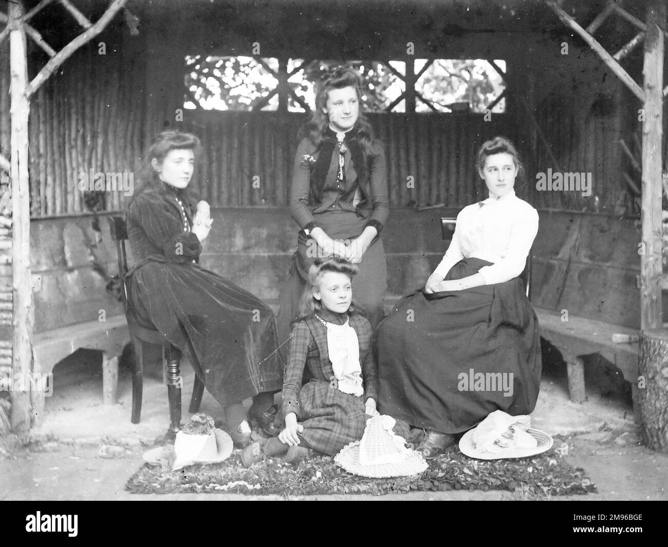 Quattro sorelle edoardiane posano per la loro foto in un gazebo rustico, probabilmente in un giardino nel Galles centrale. Foto Stock