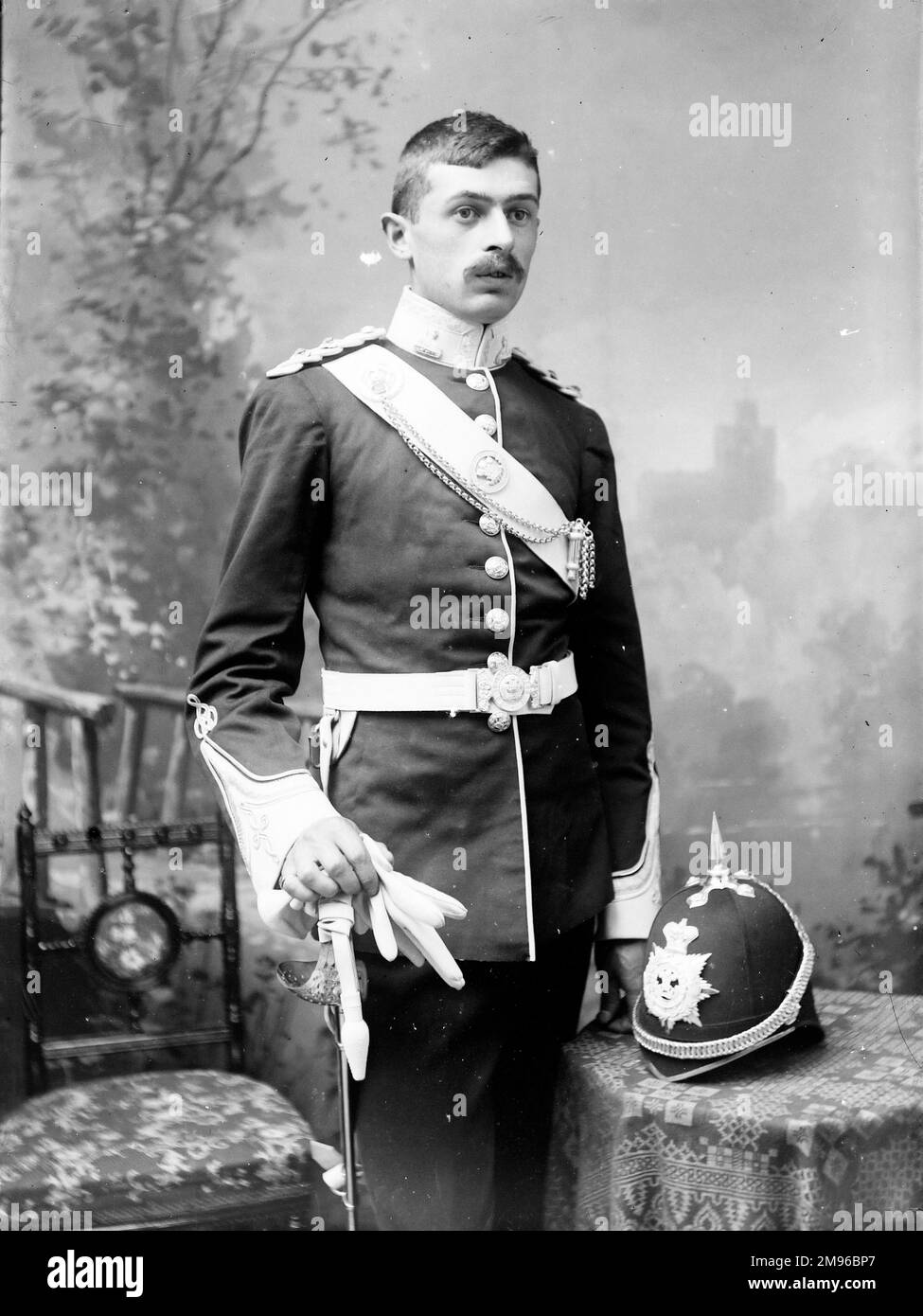Ritratto di un giovane ufficiale dell'esercito appartenente al Battaglione del Brecknockshire. E' in uniforme, completa di spada, casco e guanti bianchi, nello studio del fotografo. Foto Stock