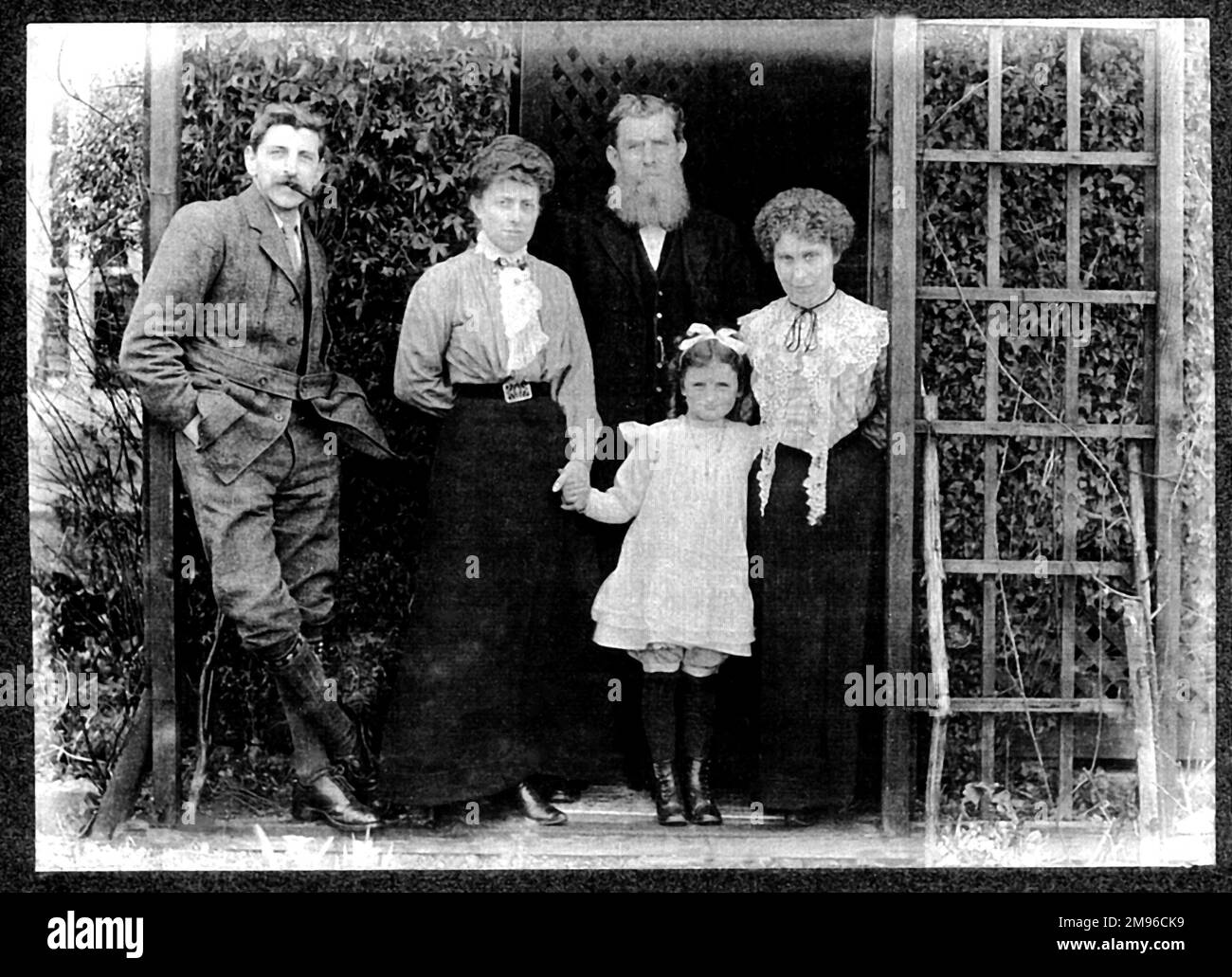 I membri della famiglia Malby (quattro adulti e un bambino) posano per una foto di gruppo in un giardino. All'estrema sinistra si trova Reginald Malby (1882-1924), fotografo ufficiale della Royal Horticultural Society, che ha un aspetto rilassato con una pipa in bocca e le mani in tasca. Foto Stock