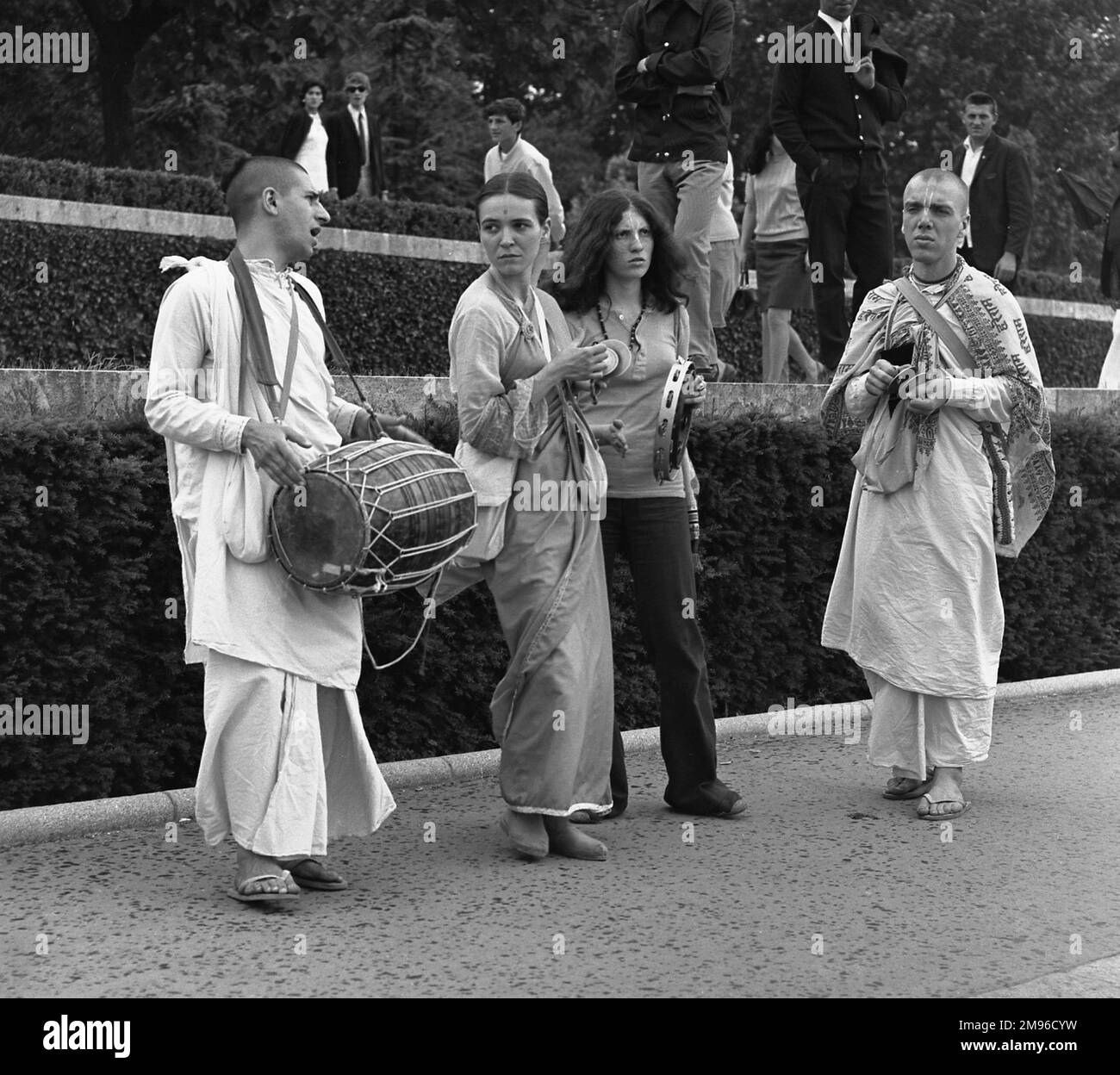 Membri della setta Radha Krishna, suonando i loro strumenti su una strada parigina. Foto Stock