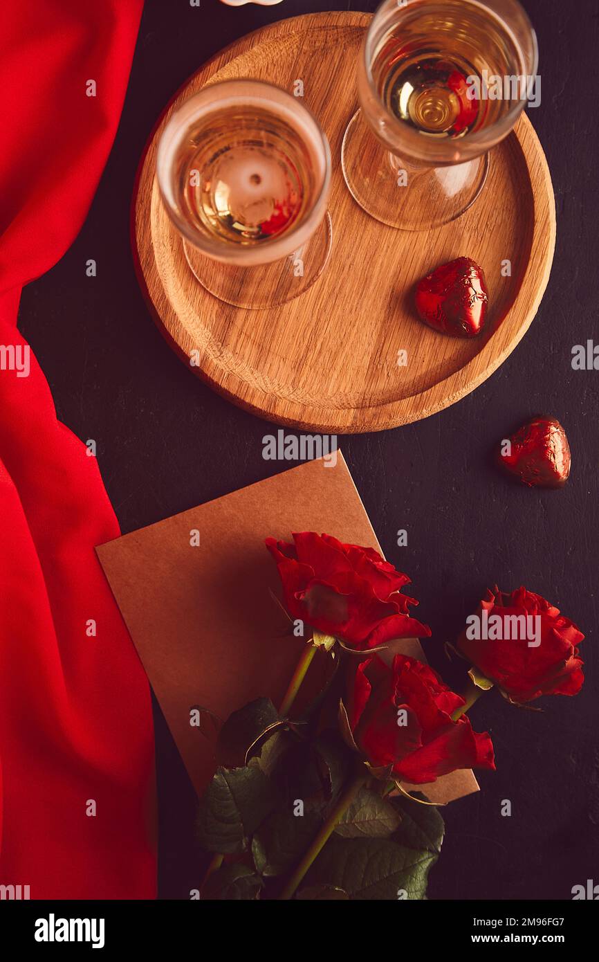 Vintage San Valentino piatto giacimento. Champagne glasess, caramelle al cioccolato e rose rosse - romantica cena stagionale piatto. Foto Stock