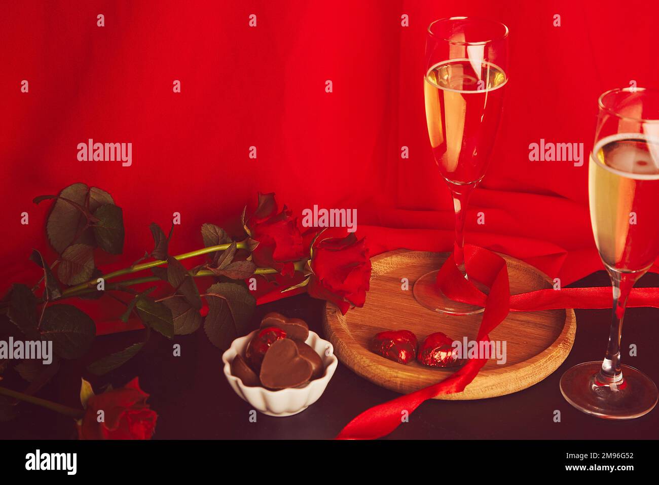 San Valentino sfondo. Rose rosse, champagne glasess, caramelle al cioccolato - romantica cena tradizionale. Foto Stock