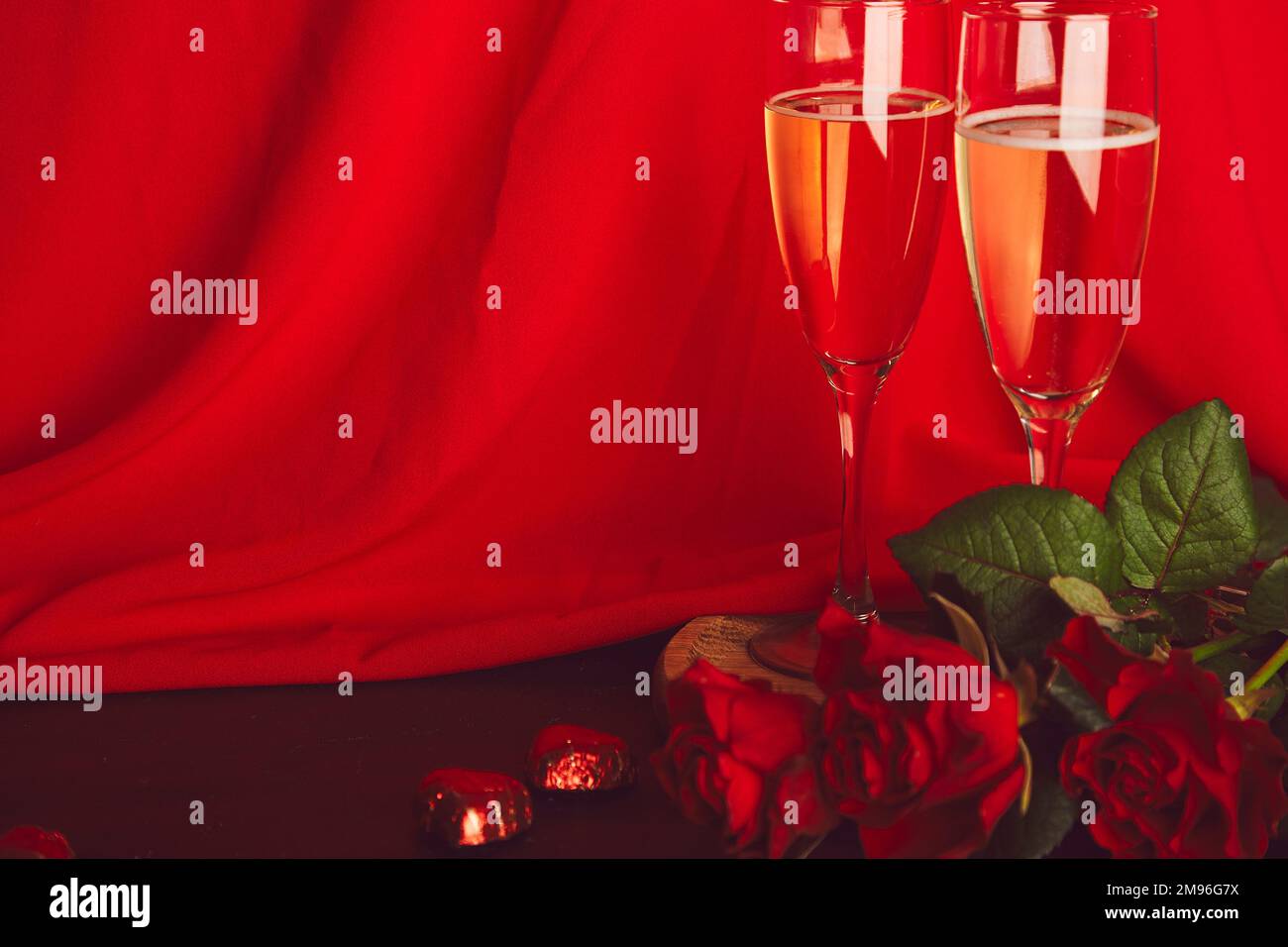 Tradizionale giorno San Valentino piatto. Rose rosse, champagne glasess, caramelle al cioccolato - cena romantica stagionale con spazio per fotocopie. Foto Stock