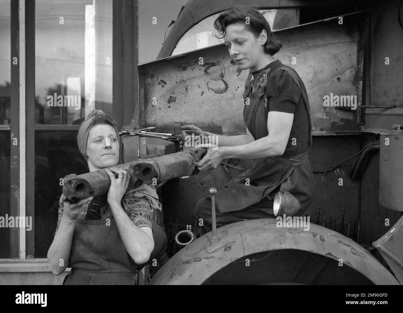 Due donne che lavorano in un garage, riparano i veicoli. Foto Stock