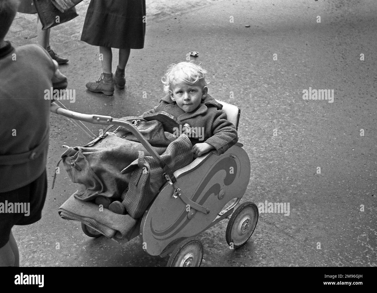 Un bambino in un passeggino, guardando verso l'alto la telecamera. Foto Stock