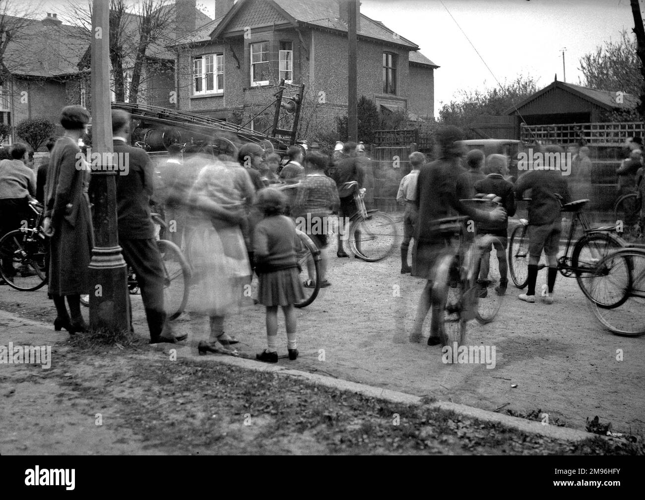 Street scene con persone che guardano un motore di fuoco in azione. Foto Stock