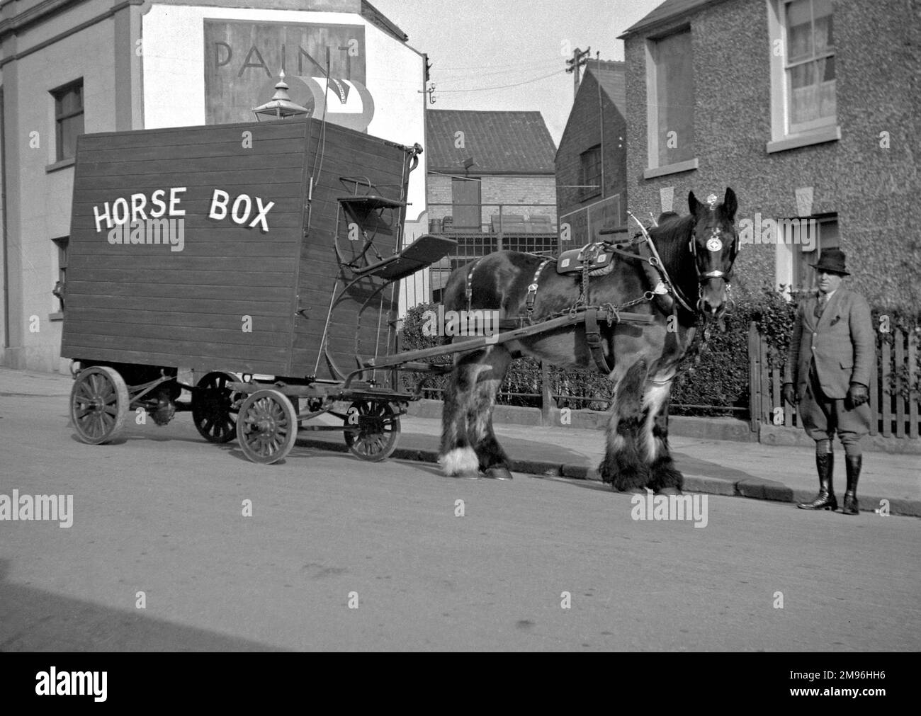 Una scatola di cavallo trainata da cavalli su una strada, con un uomo in carica che indossa dei jodphurs. Foto Stock
