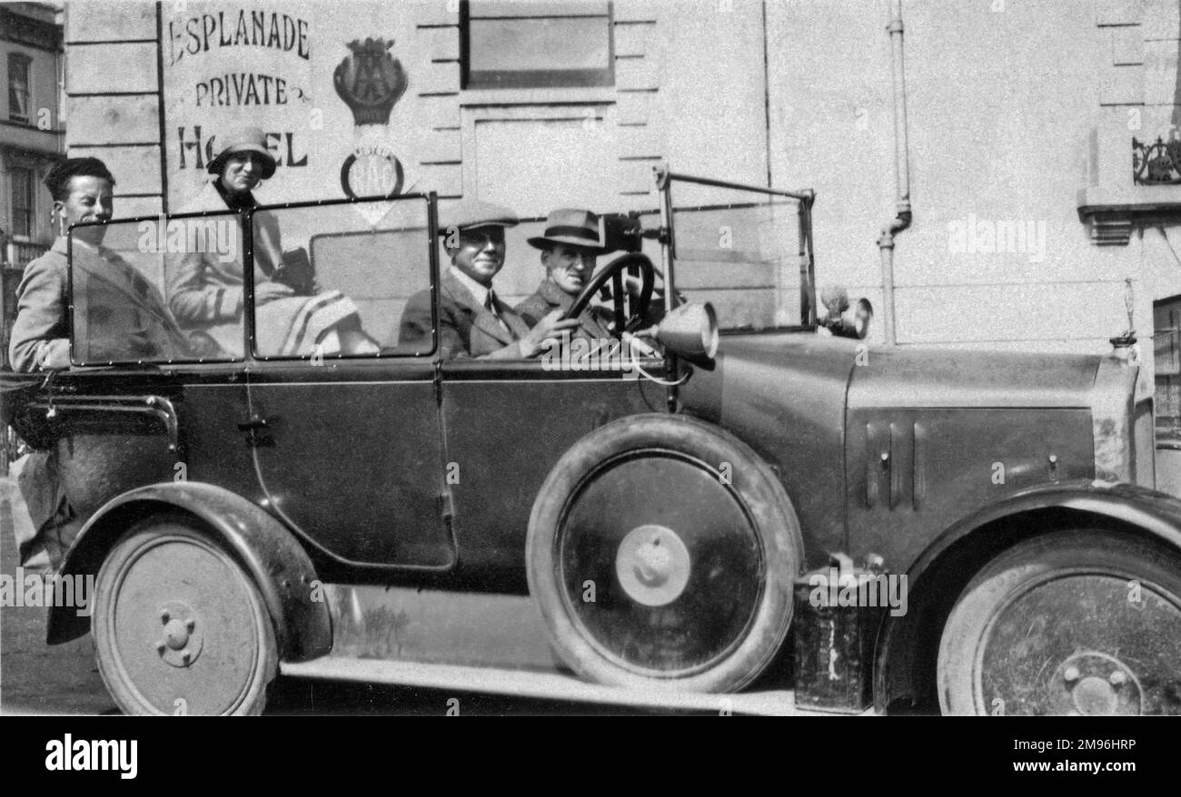 Quattro persone in un'auto scoperto in una località balneare. Foto Stock