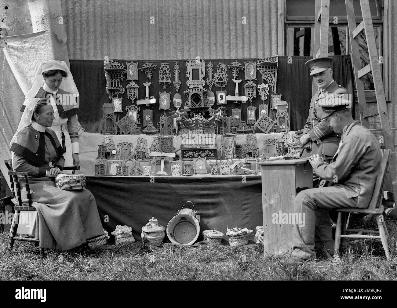 Due soldati e due infermieri in una vendita di lavoro durante la prima guerra mondiale, costituito da legno intagliato e cesti tessuti, probabilmente fatto da soldati feriti durante la terapia occupazionale. Foto Stock