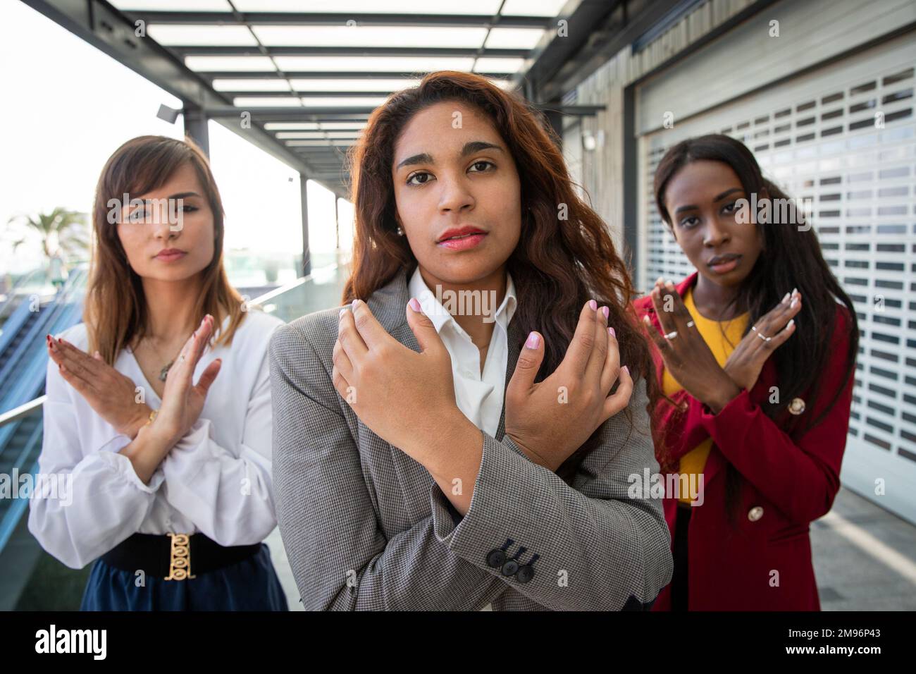Tre donne con le braccia incrociate rompono il movimento Bias a sostegno della Giornata internazionale della donna Foto Stock