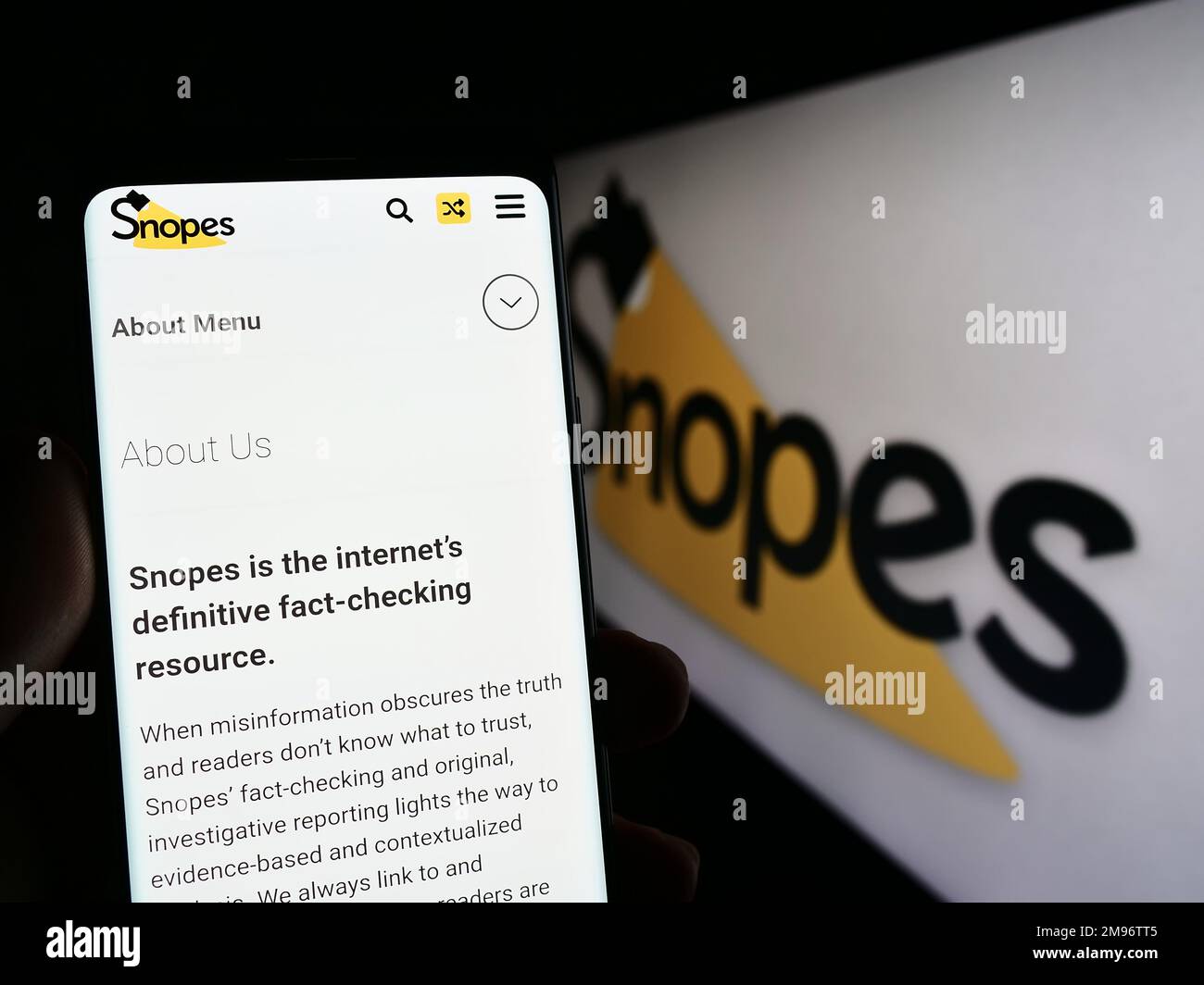 Persona che tiene il cellulare con il Web site della piattaforma di controllo di fatto degli Stati Uniti Snopes Media Group Inc. Sullo schermo con il marchio. Messa a fuoco al centro del display del telefono. Foto Stock