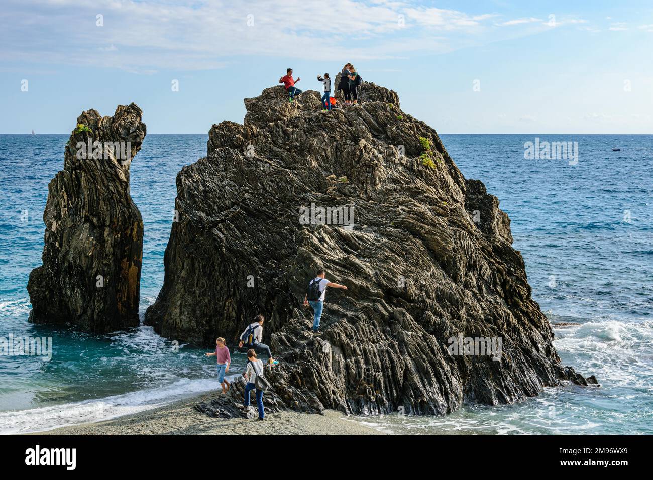 Arrampicata in famiglia sulla spiaggia di Monterosso, il paese più settentrionale delle cinque Terre. Foto Stock