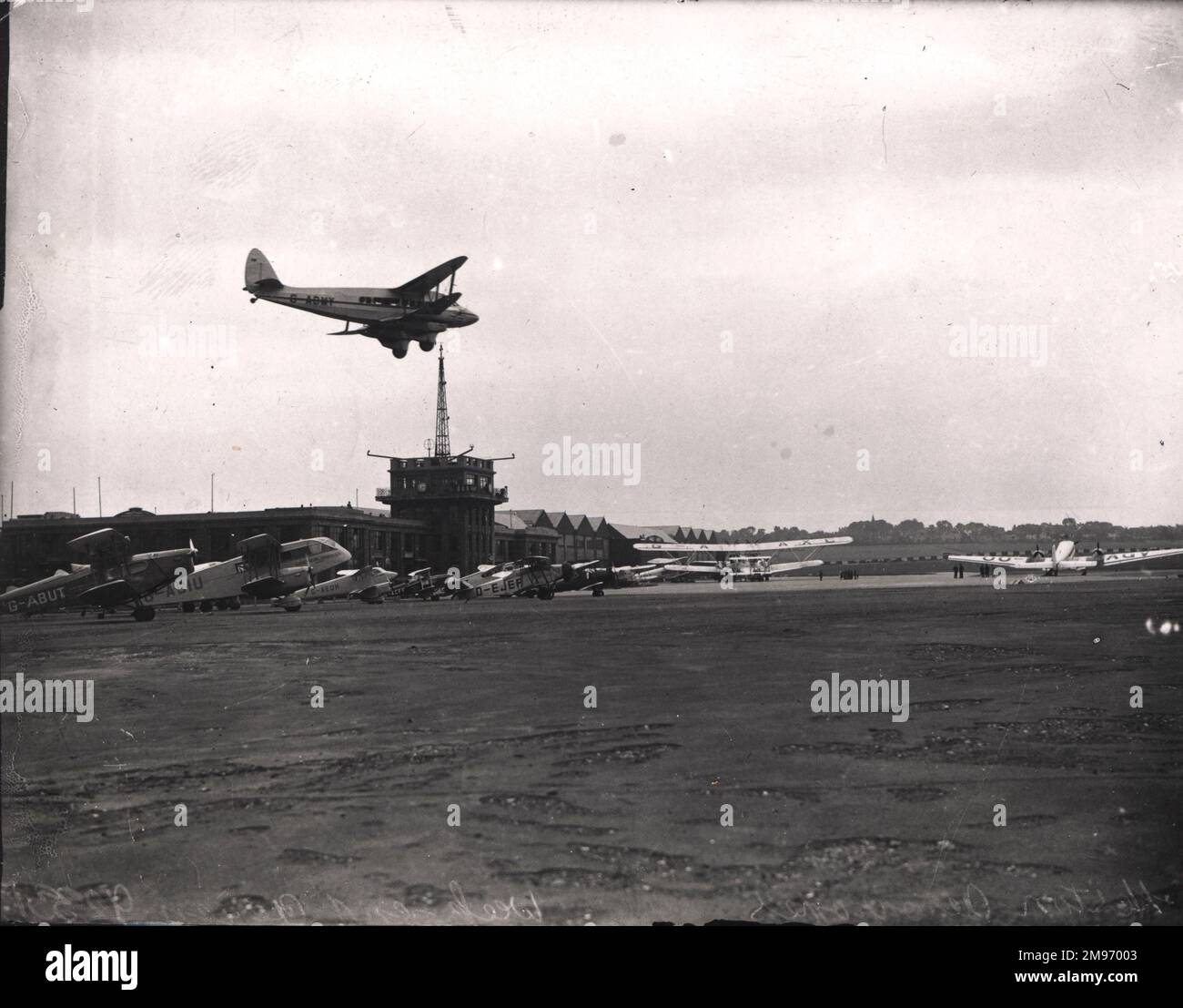 A de Havilland DH86, G-ADMY, arriva a terra all'aeroporto di Croydon. Tra gli aerei già a terra ci sono: De Havilland DH83 Fox Moth, G-ABUT; de Havilland DH84 Dragon i, G-ACIU; de Havilland DH90 Dragonfly, G-AEDH; de Havilland DH83 Fox Moth, G-ACFF; Handley Page HP42W, G-AAAXC e Junkers Ju52/3m, OO-AGV, di Sabena. Foto Stock