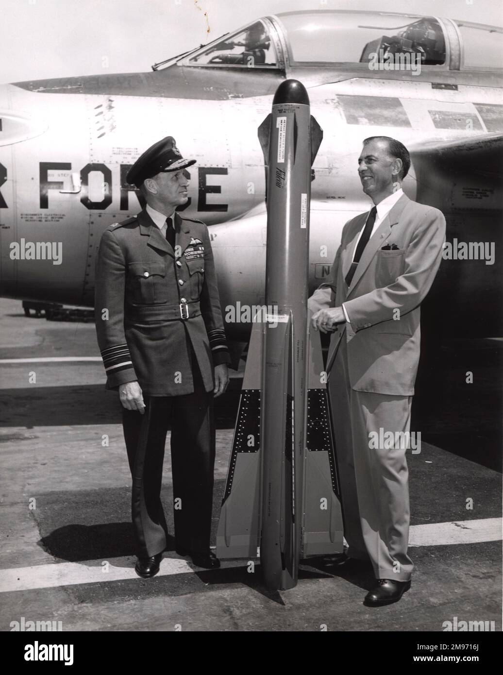 ACM Sir John Baker, controller-Aircraft, UK MOS, e un membro del Consiglio aereo, RAF, ispeziona un missile aria-aria Hughes GAR-1 Falcon presso la Hughes Aircraft Company, Culver City. A destra si trova Clarence A. Shoop, direttore delle operazioni di volo di Hughes. Dietro di loro c'è un Northrop F-89 Scorpion. Foto Stock