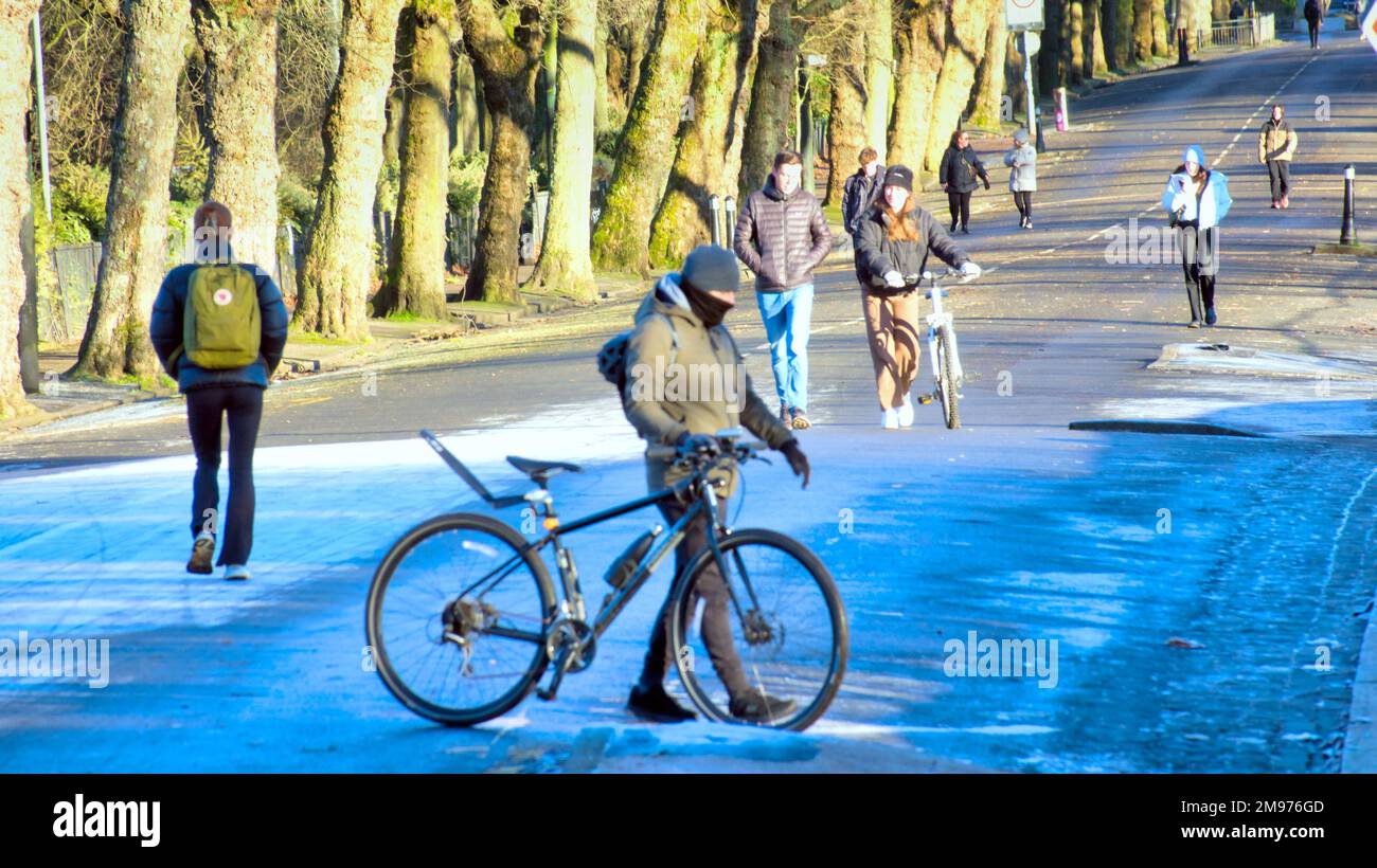 Glasgow, Scozia, Regno Unito 17th gennaio 2023. UK Weather: Freddo cielo chiaro ha visto un inizio molto freddo con la promessa di peggio per venire come la gente si è svegliata ad un wonderland di inverno e un Kelvingrove parco strada molto freddo Kelvin modo con un ciclista. Credit Gerard Ferry/Alamy Live News Foto Stock