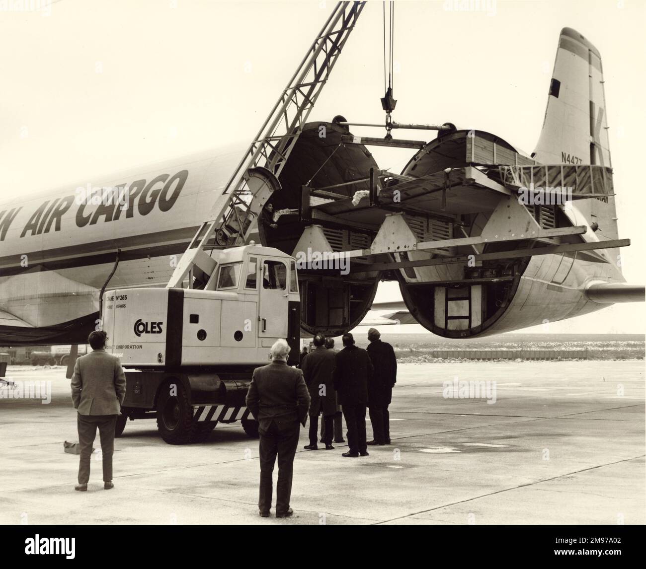 L'ala portuale di un BAC One-Eleven di Mohawk Airlines è caricata nell'unica Canadair CL-44-o, N447T, di Transmeridian Air Cargo sulla rampa di Wisley. Foto Stock