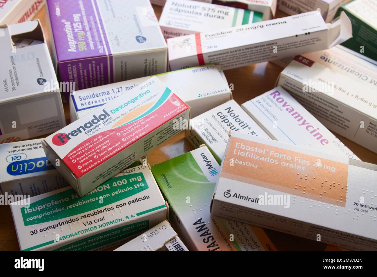 Primo piano di una tabella con molte scatole di farmaci di tutti i tipi come ibuprofene, antibiotici, nolotil, ecc. Foto Stock