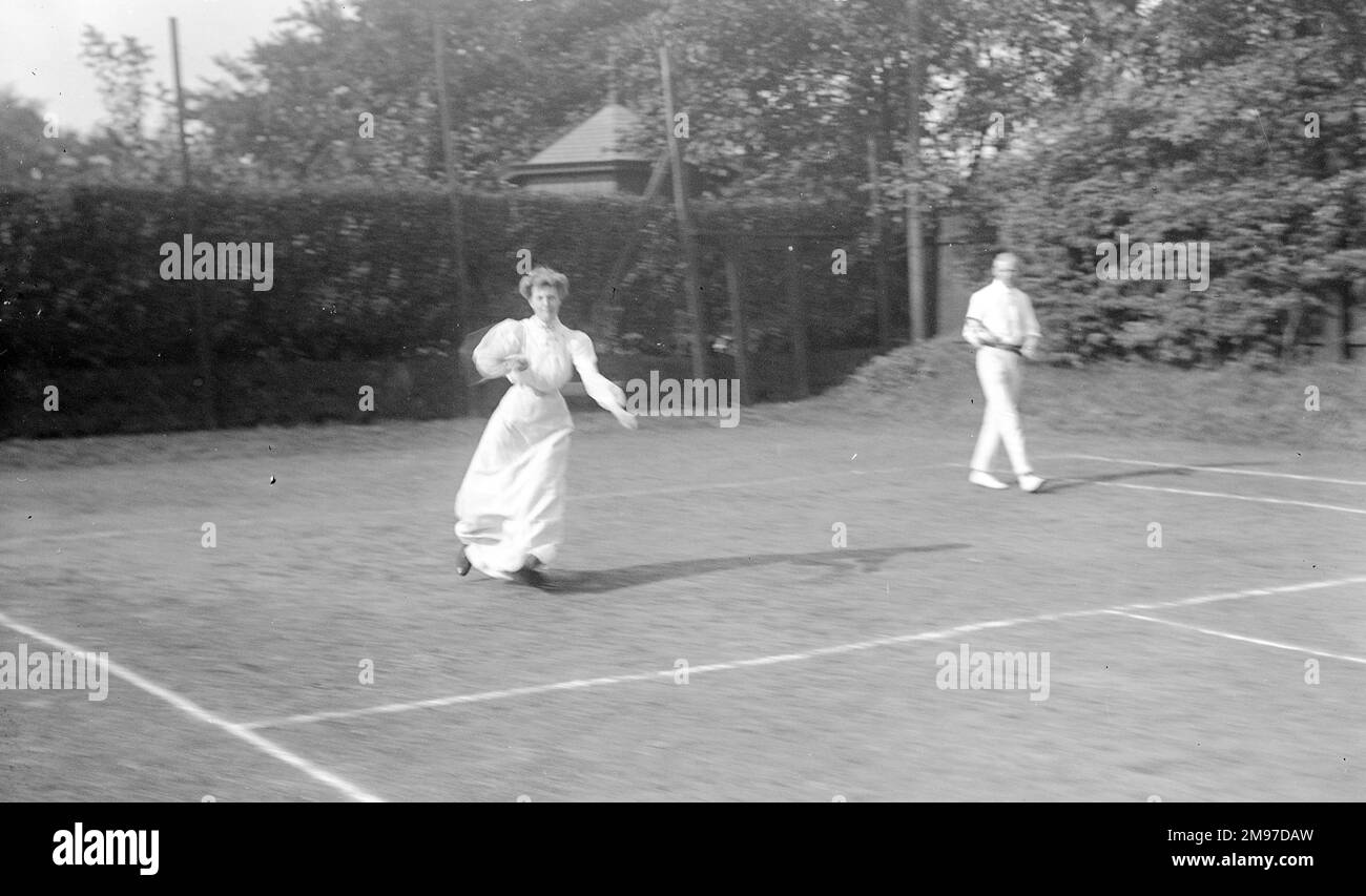 Torneo di tennis edoardiano che mostra una partita di doppie miste in corso Foto Stock