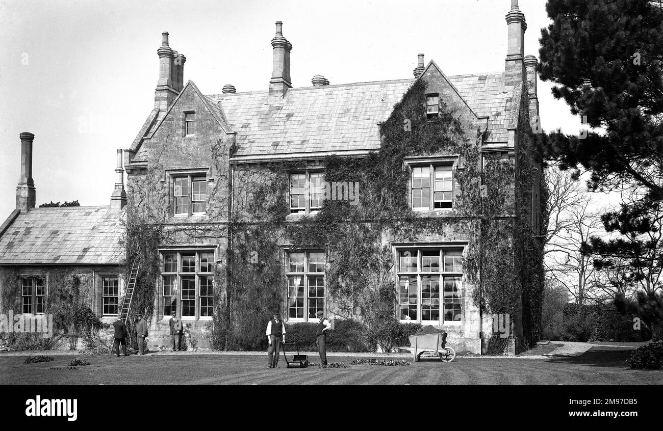 Blisworth Vicarage, Northamptonshire, mostra il personale di giardinaggio al lavoro. Si noti la massiccia carriola che sarebbe pesante anche prima che fosse stata riempita con erba fresca tagli! Foto Stock